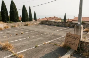 Parking gratuit en bord de mer près de Pise avec panneau en italien et vue sur la côte méditerranéenne
